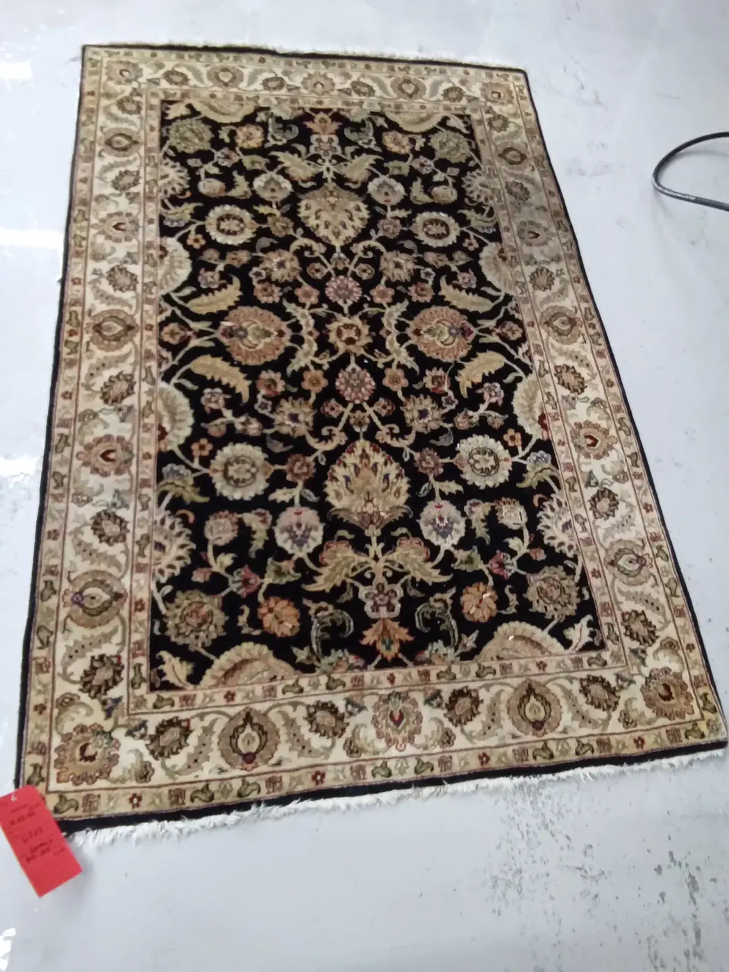 Navy floral Persian rug spread flat after cleaning